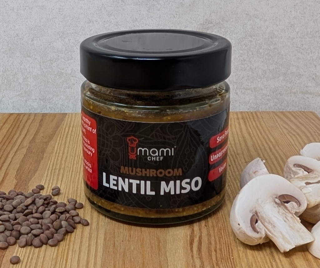 Jar of lentil miso showing the green lentils and mushrooms used to create it